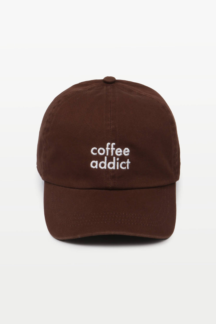 Close-up of COFFEE ADDICT embroidery on a casual cotton baseball hat.
