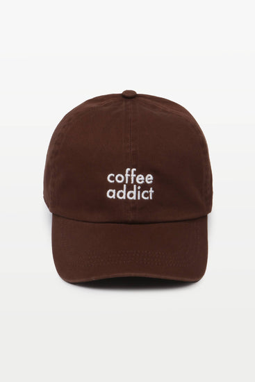 Close-up of COFFEE ADDICT embroidery on a casual cotton baseball hat.